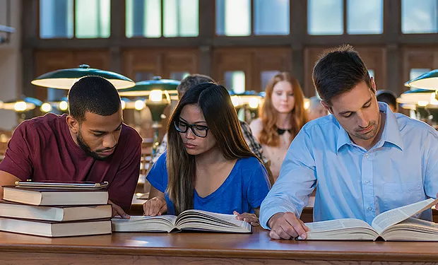 3 students studying in a library